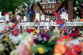 Flowers and other items surround crosses at a memorial in June 2022 for the victims of a mass shooting at Robb Elementary School in Uvalde, Tex.